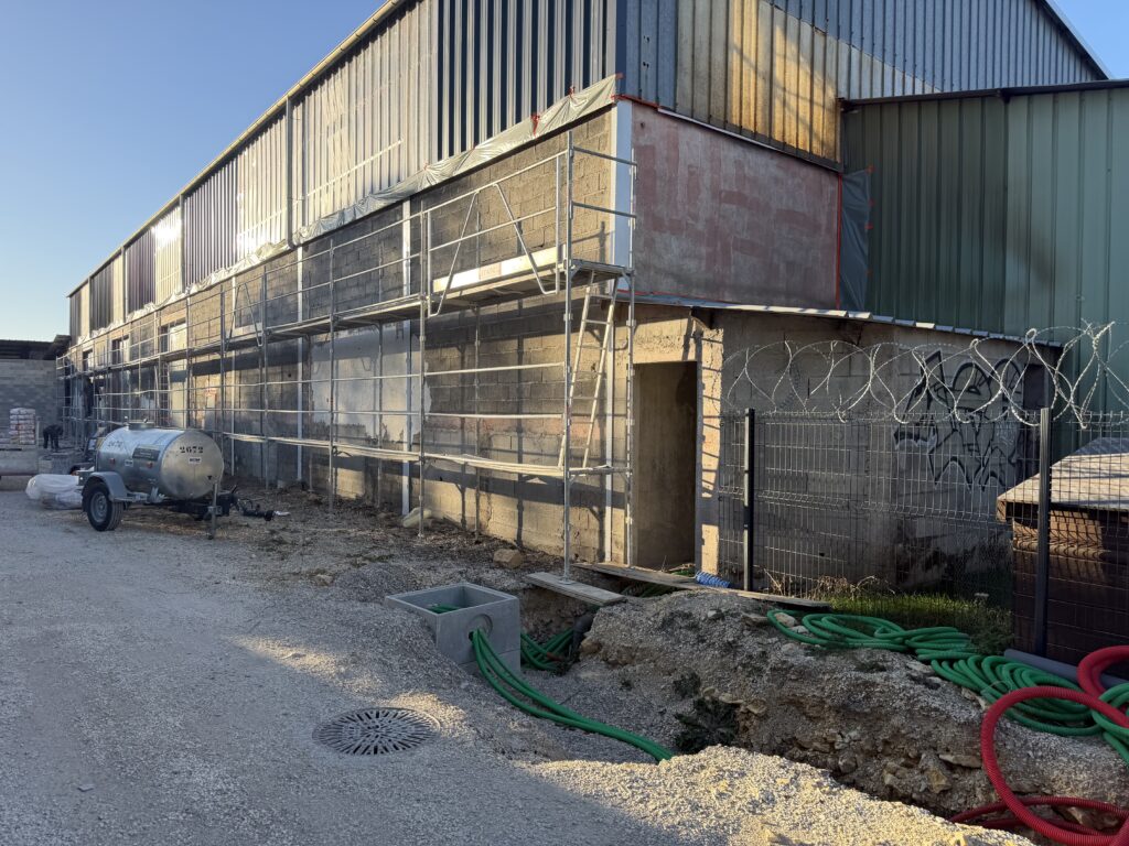 Façade en béton avant préparation et application d'un nouvel enduit monocouche sur un dépôt à Chevigny saint Sauveur